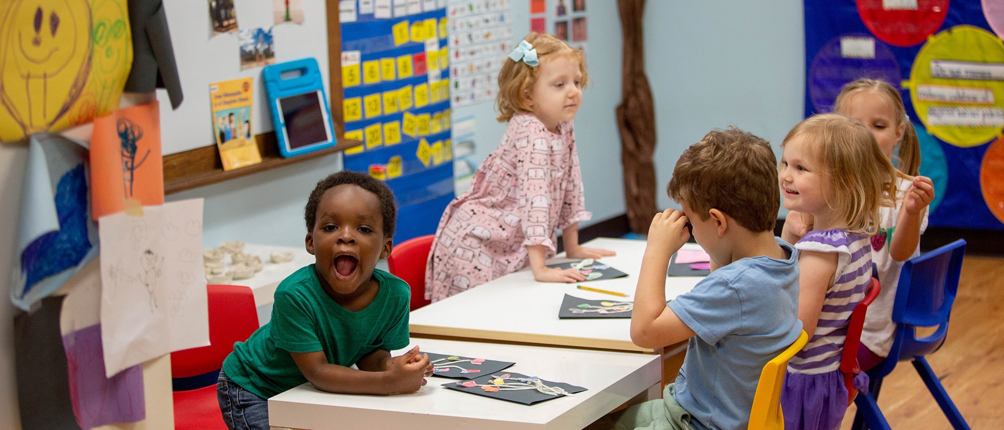 preschool students working on their projects sitting at the table