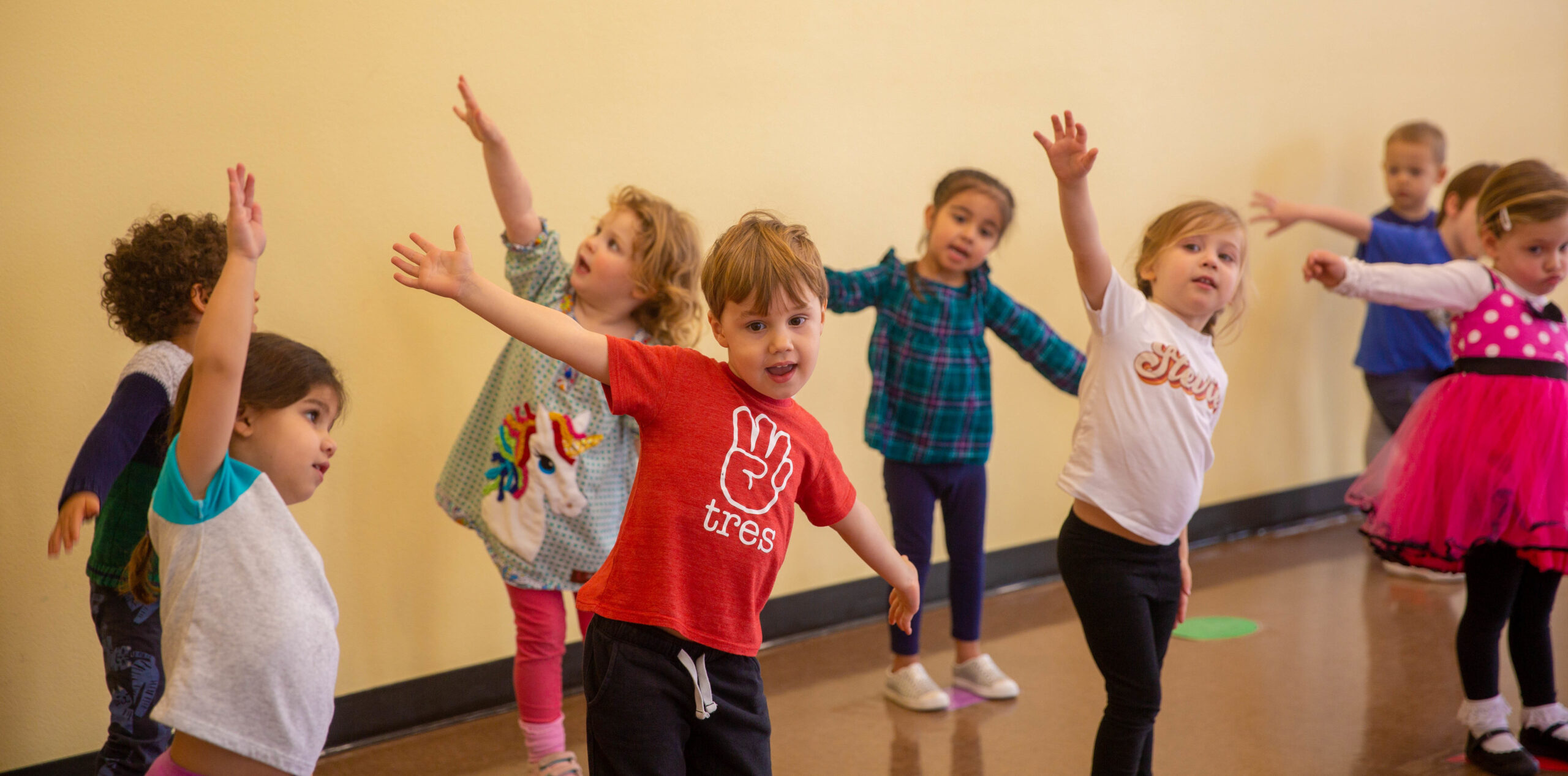 Spanish World School Elementary students exercise and stretch in the gym.